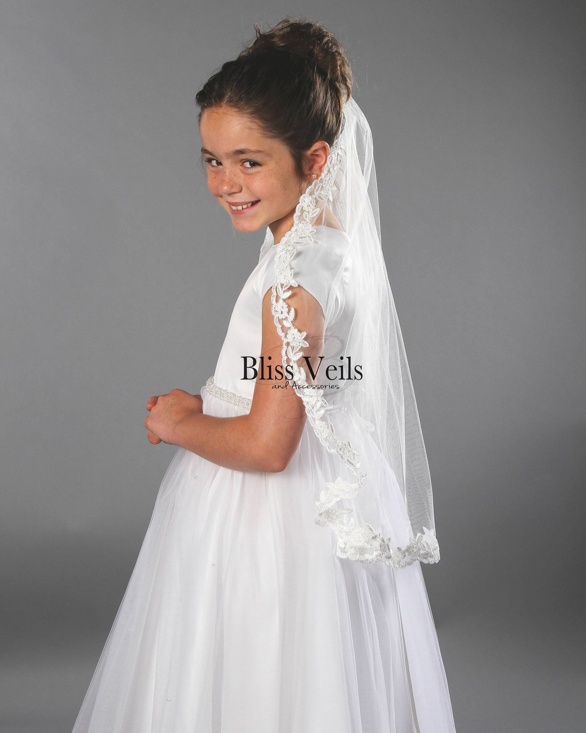 Soft tulle First Holy Communion veil with lace trim shown in bright white for a classic ceremony look