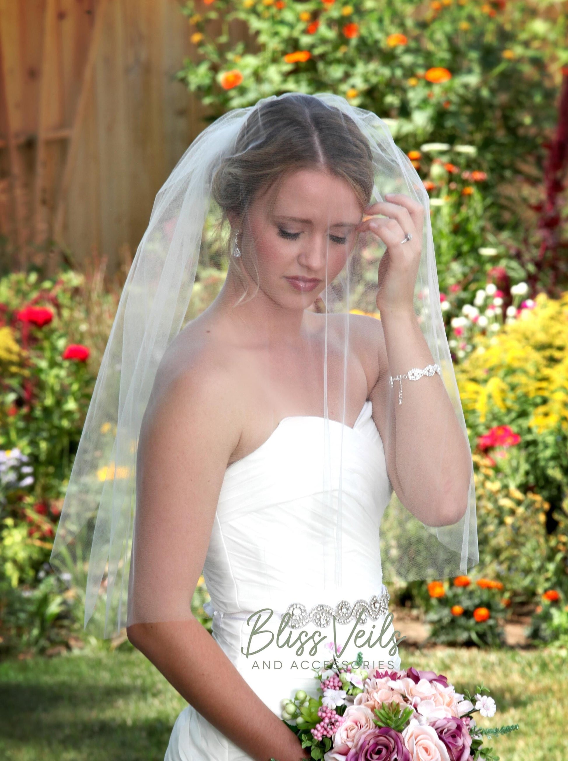 Sheer raw edge blusher veil add on in soft tulle with metal comb layered over a wedding veil